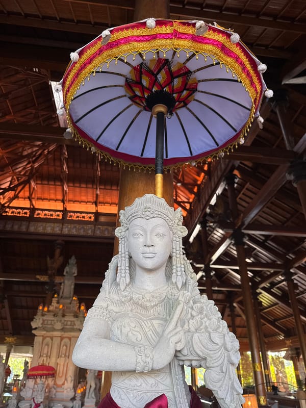Tourist documents Balinese temple complex with statues and gardens