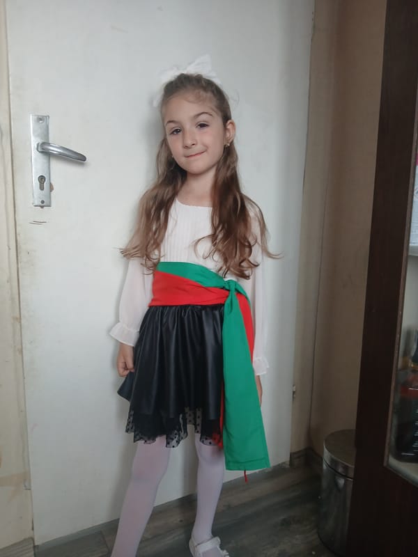Girl in traditional dress observed on door in Bulgaria