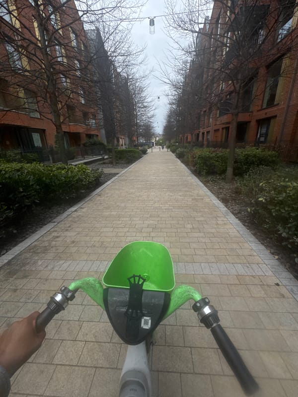 Person rides electric scooter on brick pathway in London
