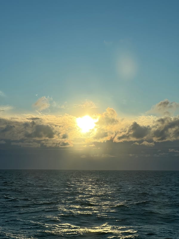 Sun breaks through clouds over a calm Baltic seascape