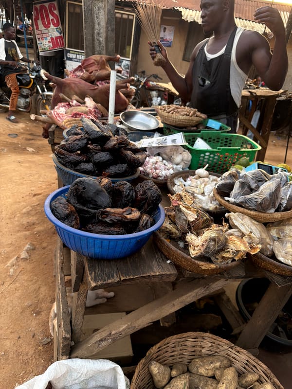Man sweeps near meat vendors at Nigerian marketplace