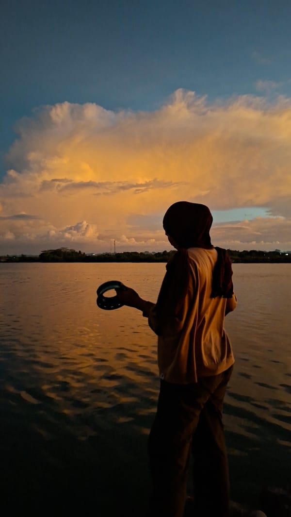 Sunset at the Lhokseumawe waterfront, silhouettes at the water's edge