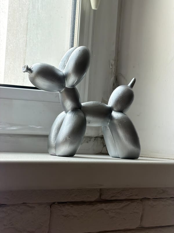 Silver balloon dog figurine spotted on window frame