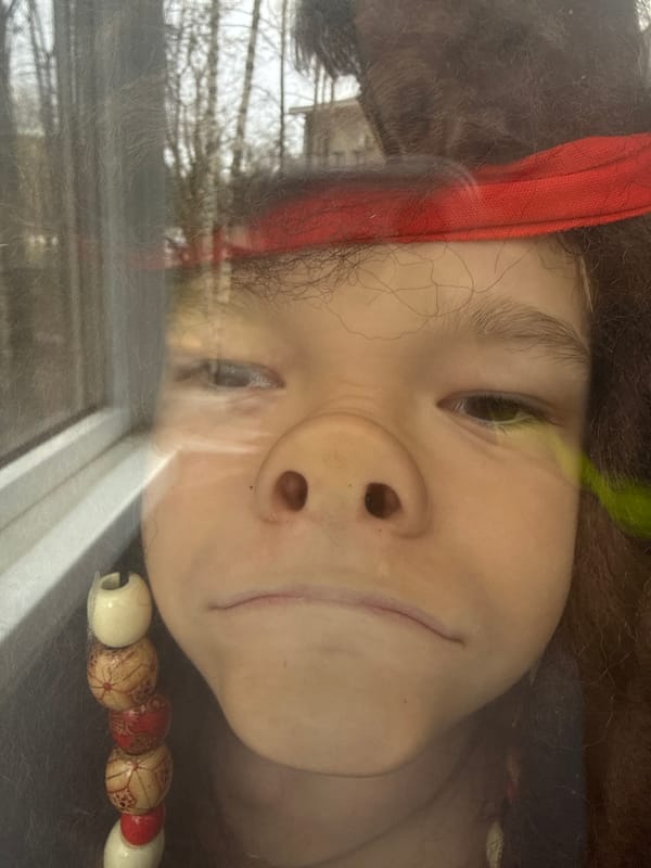 Child watches winter trees through window in Dmitrov