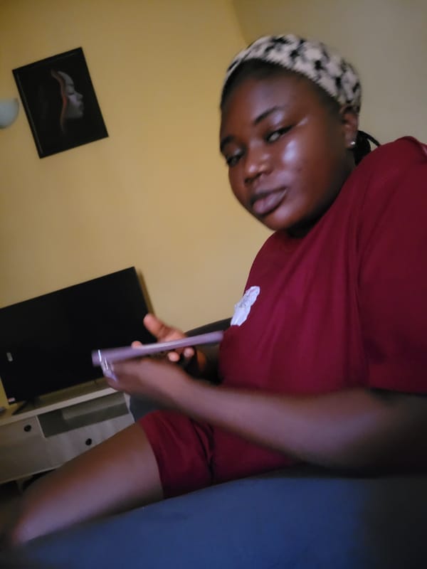 Inside a yellow-walled room in Suleja, phone in hand