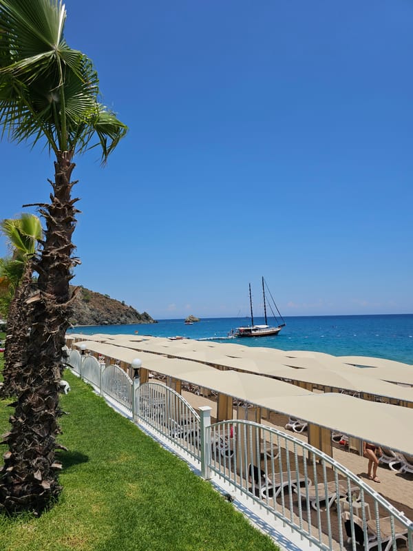Sunny day at a beachside resort with boats offshore