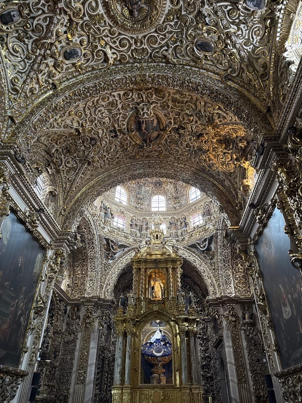 Visitor documents ornate Baroque church interior in Puebla, Mexico
