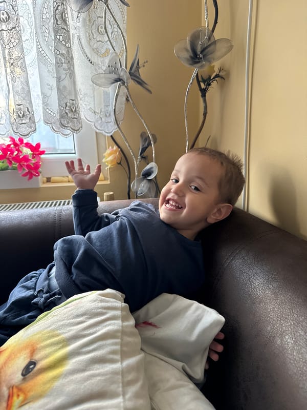 Toddler plays mobile games on couch in Belene
