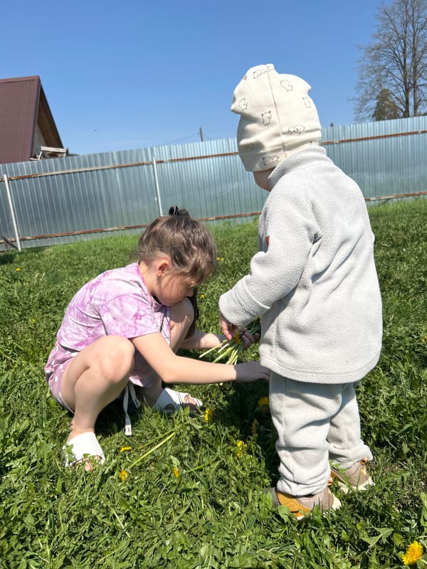 Children play with dandelions in Chaikovsky park