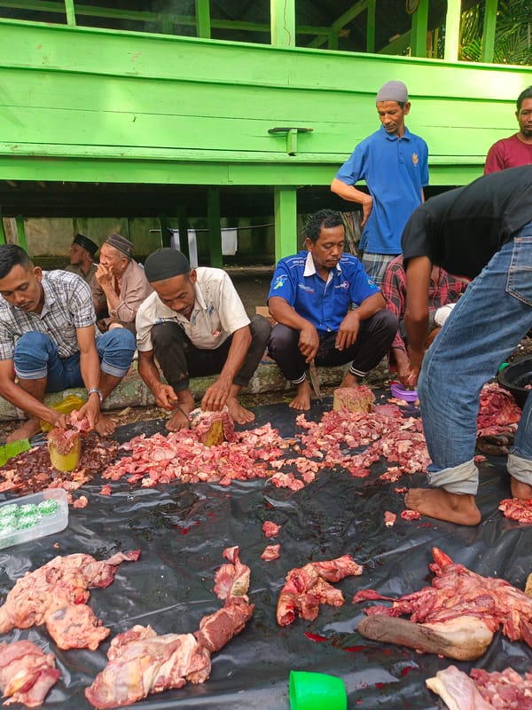 Communal cooking and meat prep at an outdoor gathering in Payakambuk