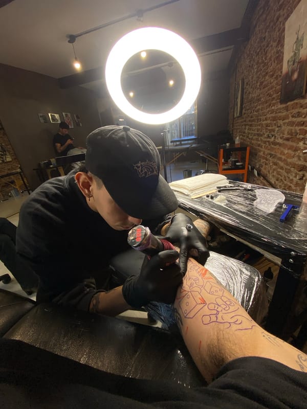 Tattoo artist works on client's forearm in Buenos Aires studio