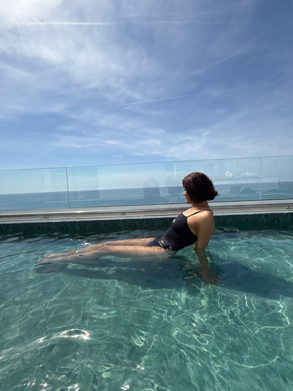 Woman enjoys morning swim at rooftop pool in Calella
