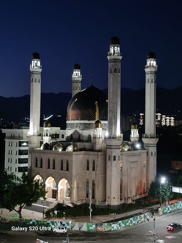 Almaty at dusk: mosque and skyline lit up for the night