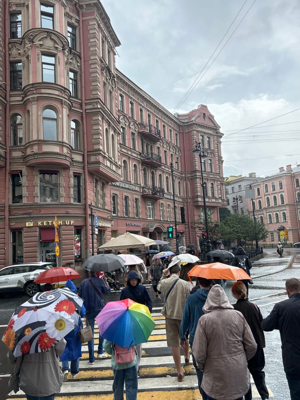 Rainy city crosswalk scene with umbrellas and ornate architecture