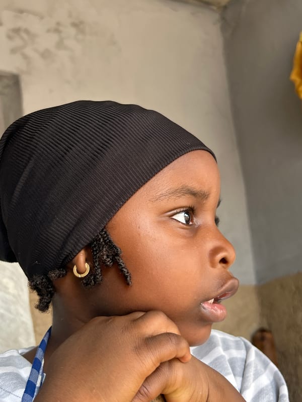 Child uses traditional mortar and pestle in Jos, Nigeria