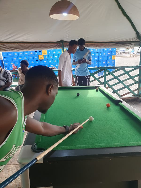 Young men play casual pool game in Lokoja recreational space