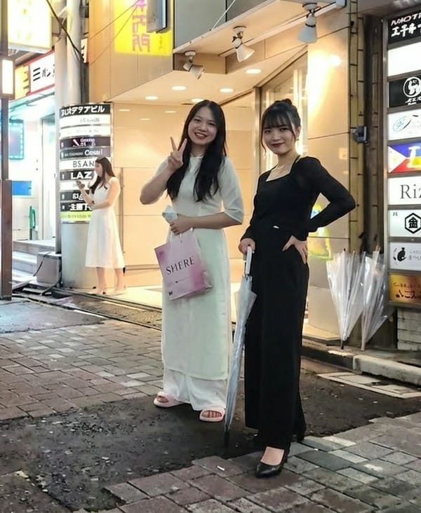 Young women pose for photos on Shinjuku streets