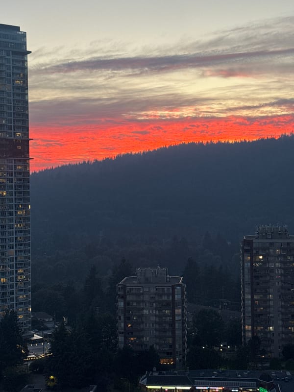 Coquitlam sunset behind forested hills and city towers