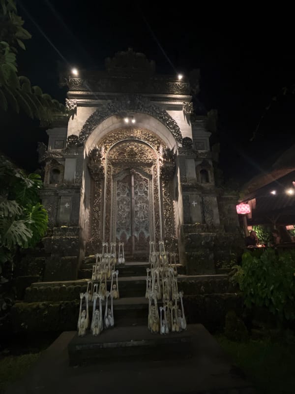 Ornate Balinese temple entrance glowing under night lights