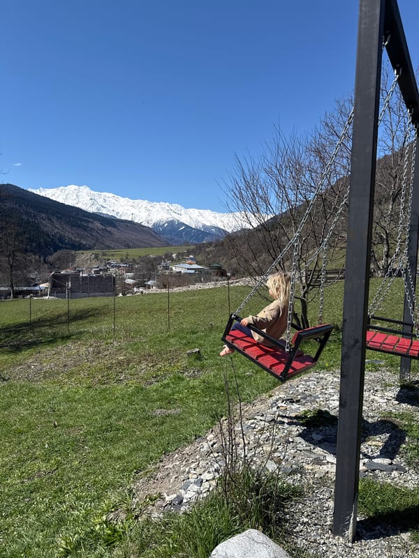 Child plays amid mountain scenery in Mestia, Georgia