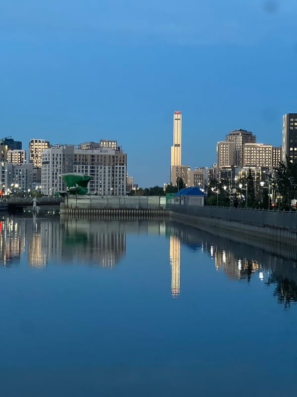 Evening fishing and cityscape reflections along Astana's Ishim River