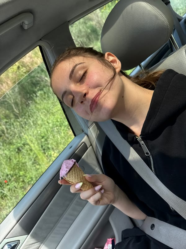 Woman enjoys ice cream in car passenger seat, Tsarevo