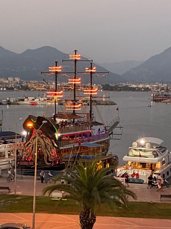 Alanya harbor at dusk: pirate ships, promenades, and street life