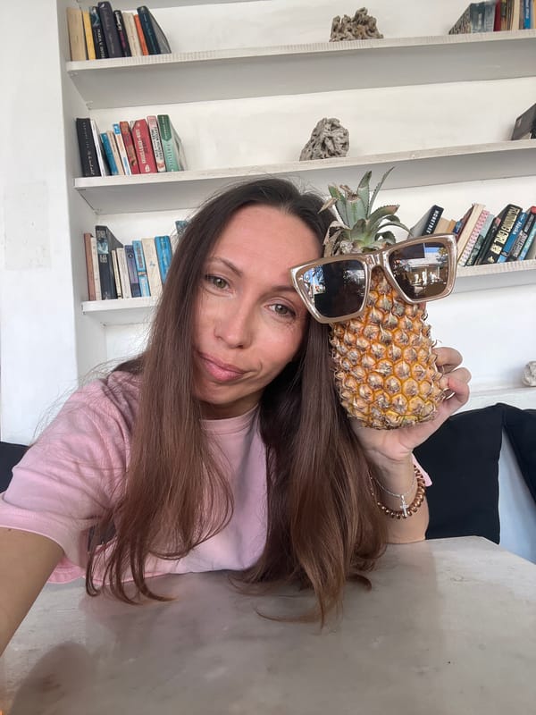 Woman poses with sunglasses-wearing pineapple in North Kuta home