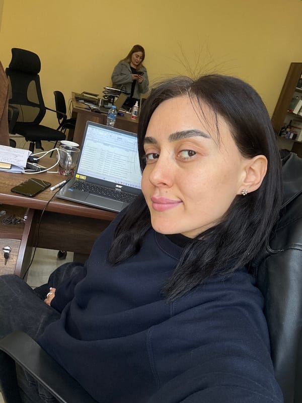 Woman works at desk in Tbilisi office with decorated cake