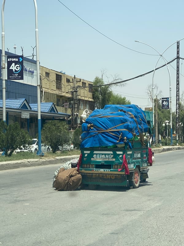 Teal cargo truck parked roadside in Kandahar, Afghanistan