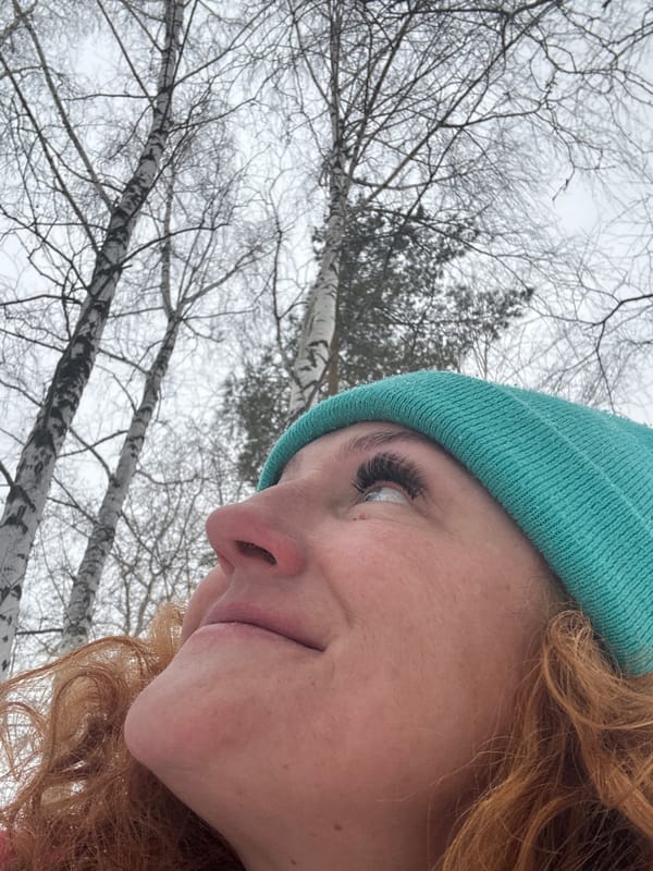 Woman plays with boxer dog in snowy Russian forest