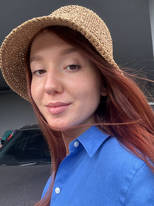Red-haired person in straw hat observed indoors in Thailand