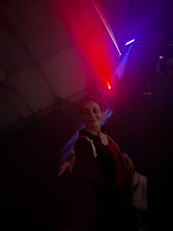 Inside a laser-lit party venue, dancing and selfies.