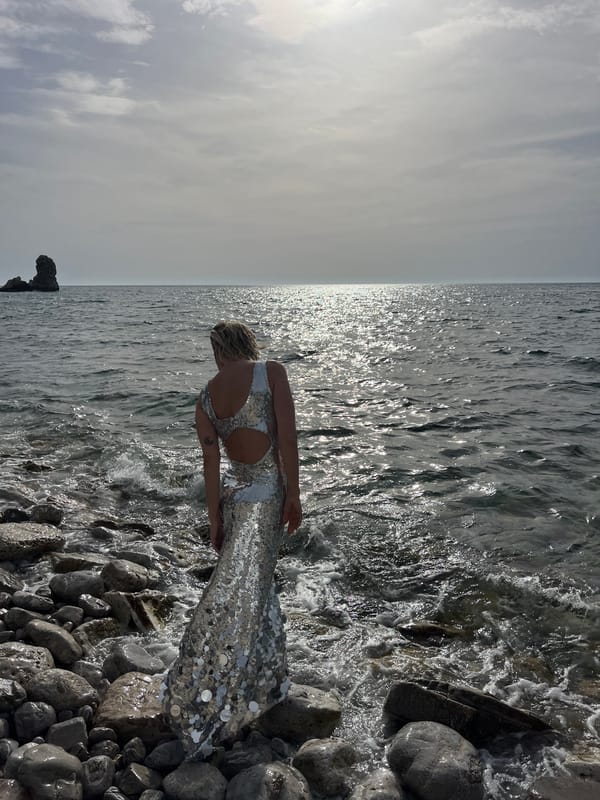 Woman contemplates sea from rocky Montenegro beach