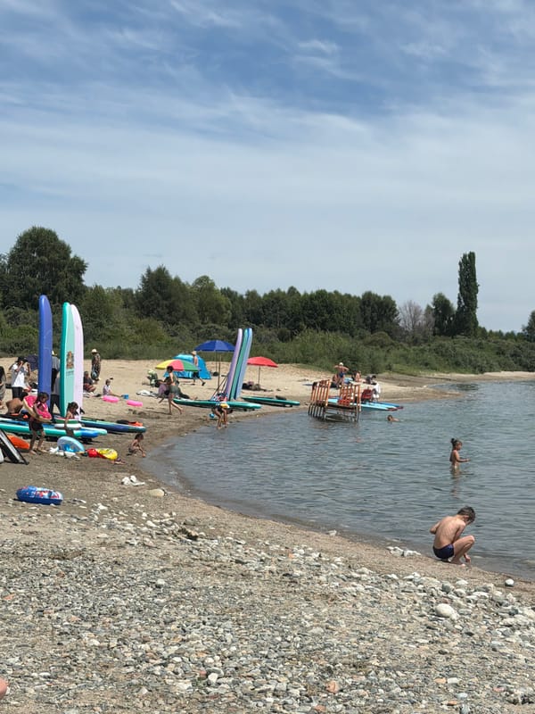 Wading, bathing, and paddleboarding near a mountain-backed lake