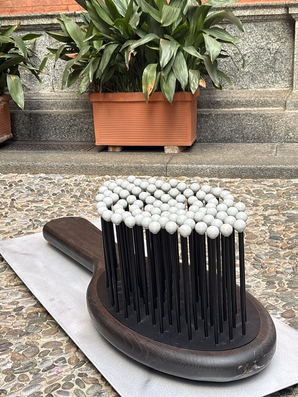 Person examines outdoor display with sculpture in Milan