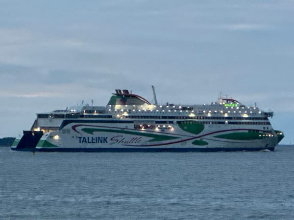 Tallinn's Baltic shore at dusk, ferries passing, beach nearly empty