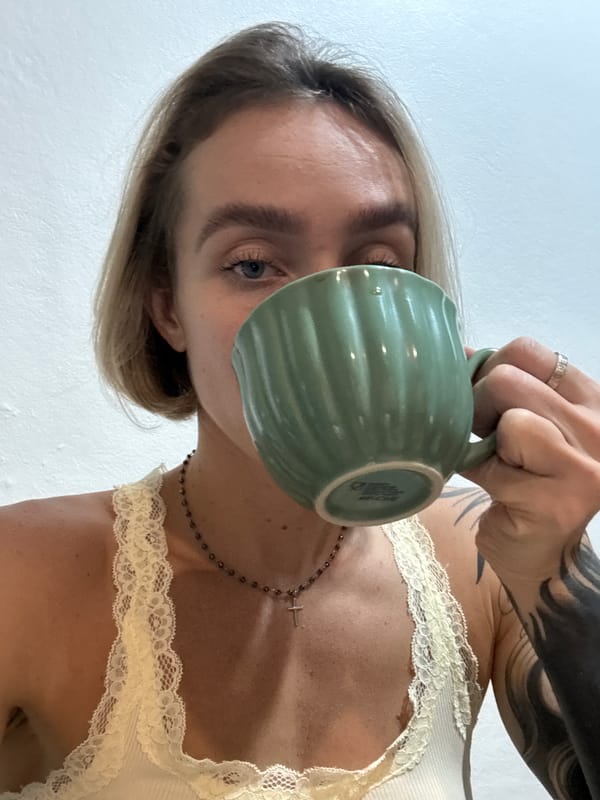 Woman drinks from green mug in Karon, Thailand