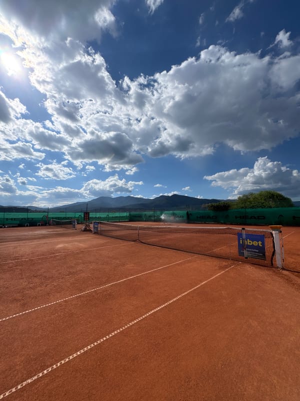On a red clay court in Velingrad, racket in hand.