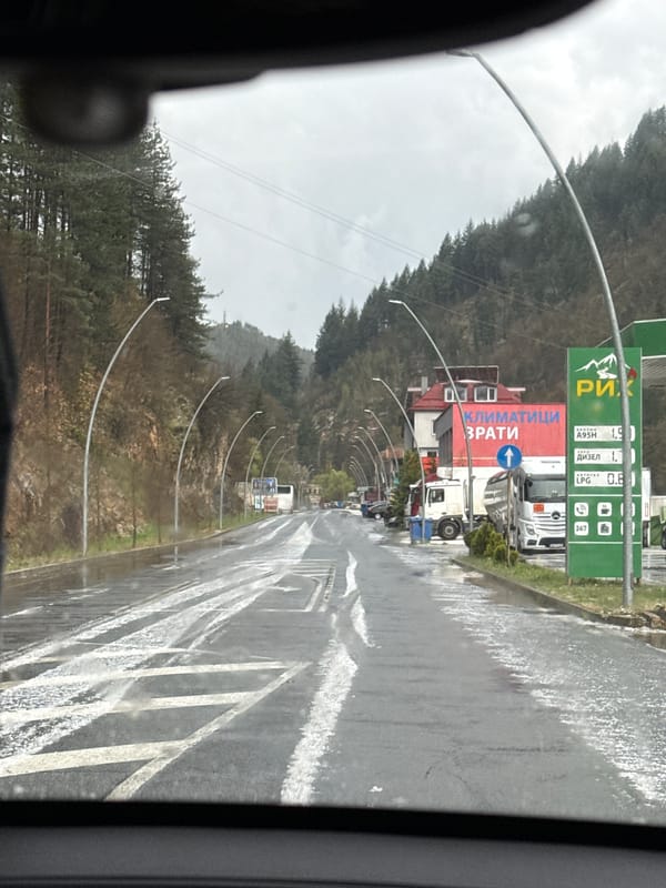 Vehicle travels wet mountain road in Madan, Bulgaria