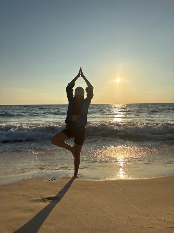 Person performs stretching pose on Choeng Thale beach