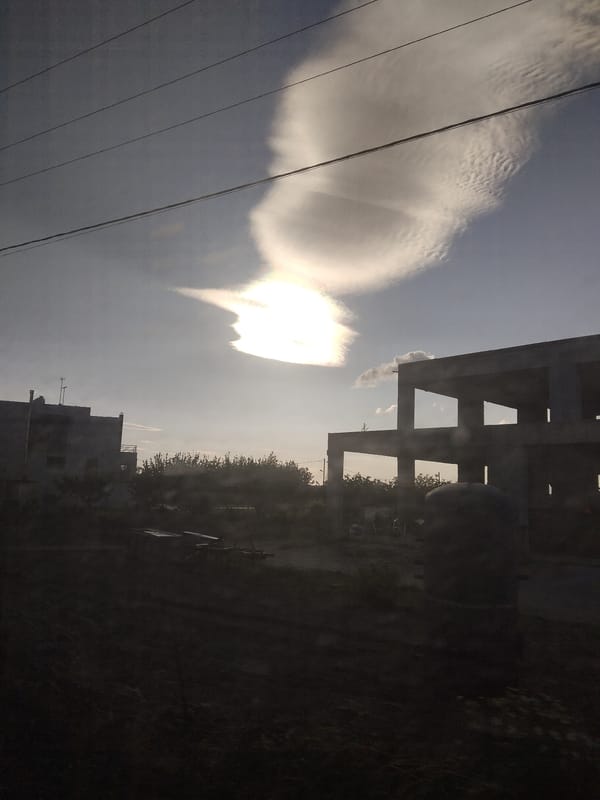 Vehicle passenger photographs dramatic clouds over Greek landscape