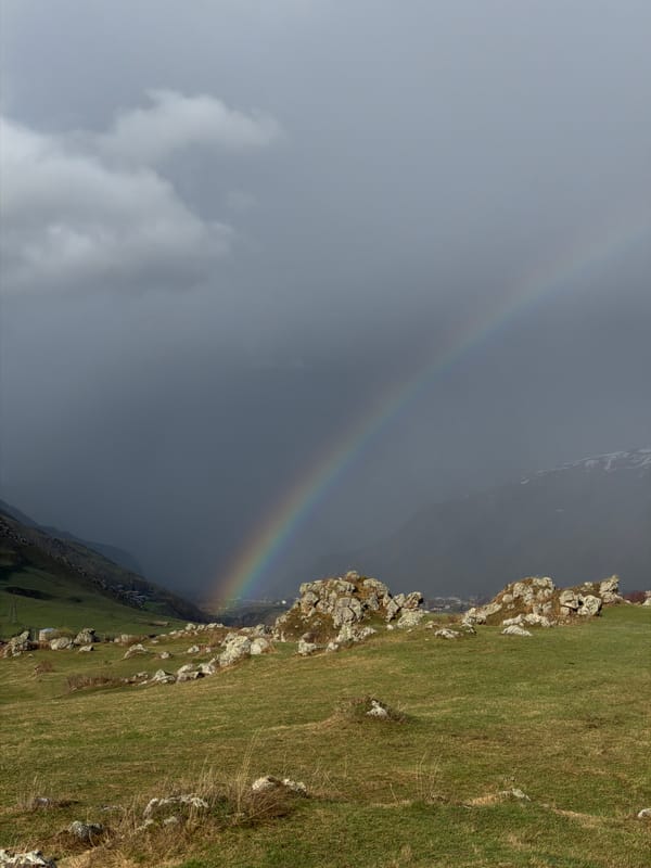 Rainbow appears over green hillside in Sioni, Georgia