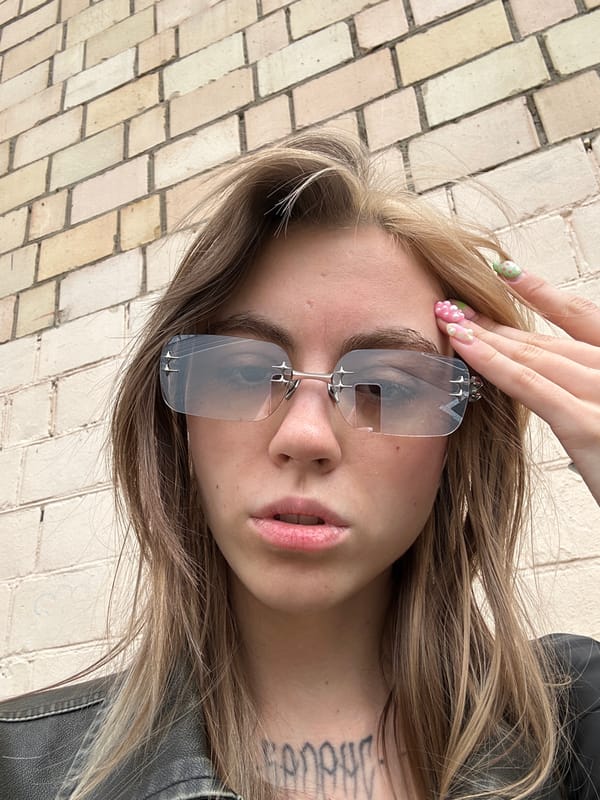 Leather jacket and reflective shades near a Moscow brick wall