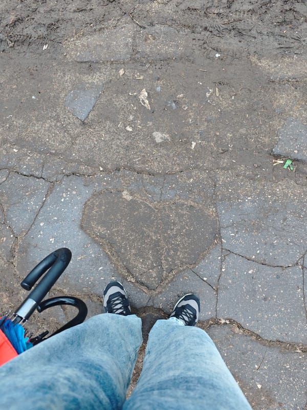 Person stands on heart-shaped pavement patch in Samara