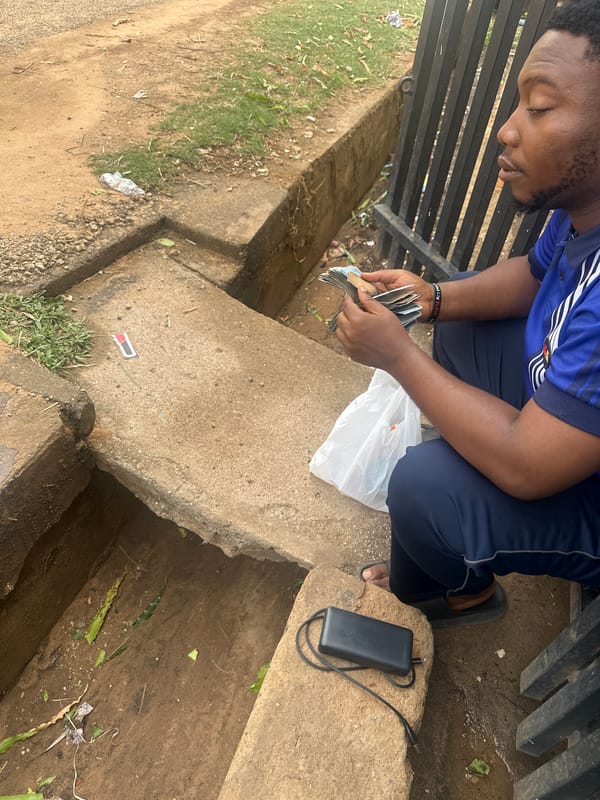 Man counts money outdoors in Barden Yana, Nigeria