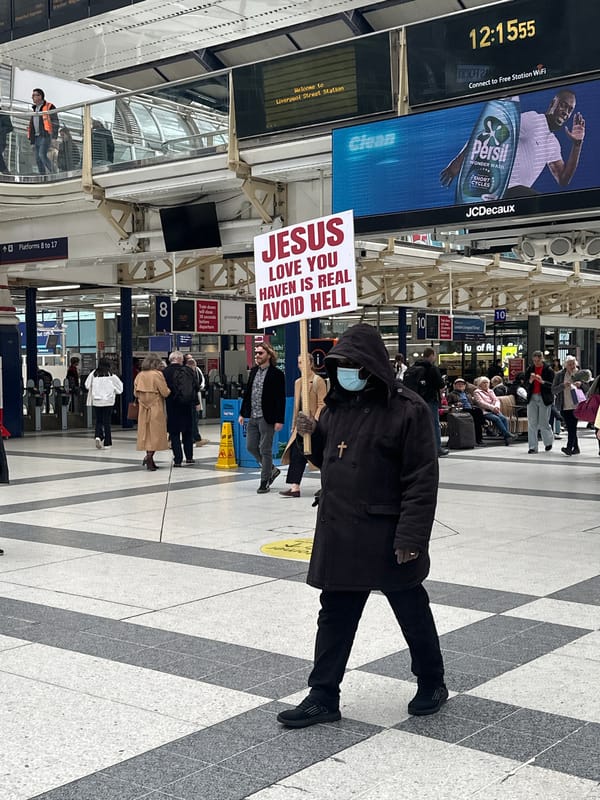 Religious preacher displays sign at Liverpool Street Station