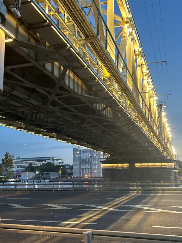 Dusk to night around an illuminated urban waterfront and bridge