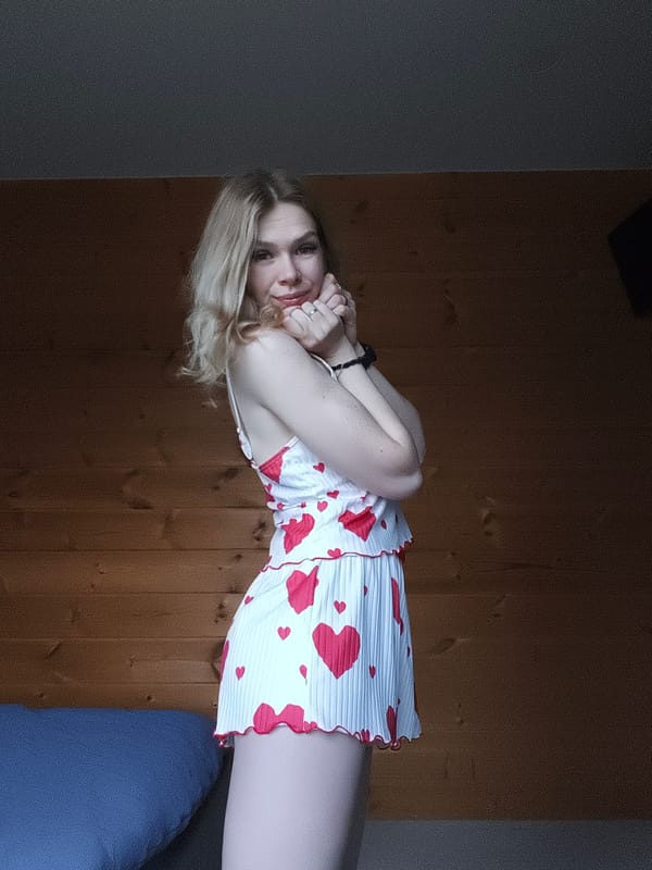 Woman poses in heart-patterned dress indoors in Russia