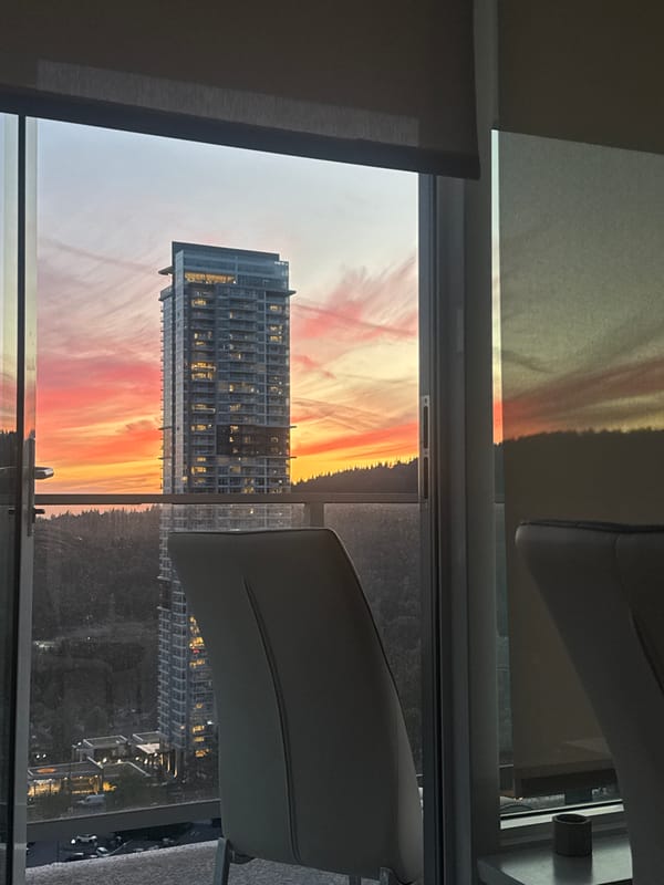Sunset over Coquitlam framed through a high-rise window